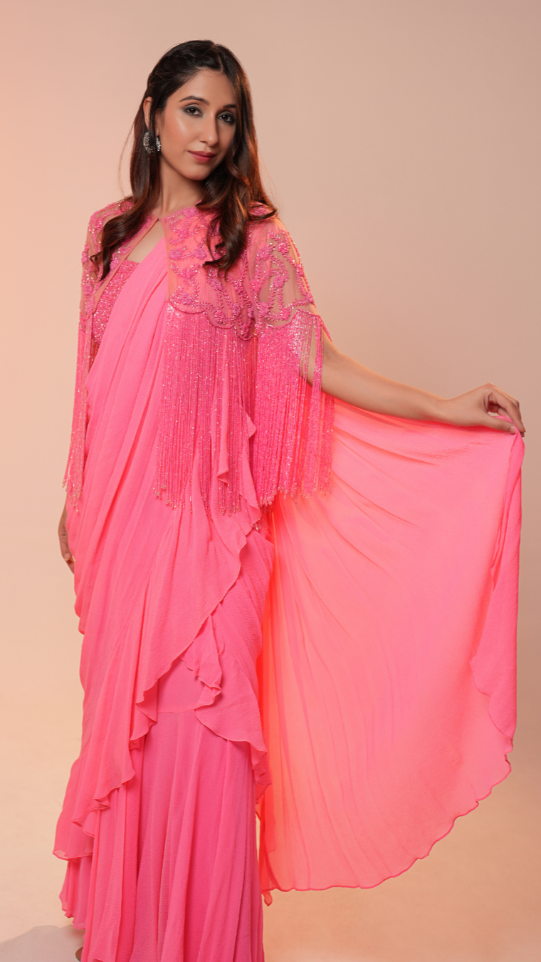 Woman wearing a pink saree with a plain background