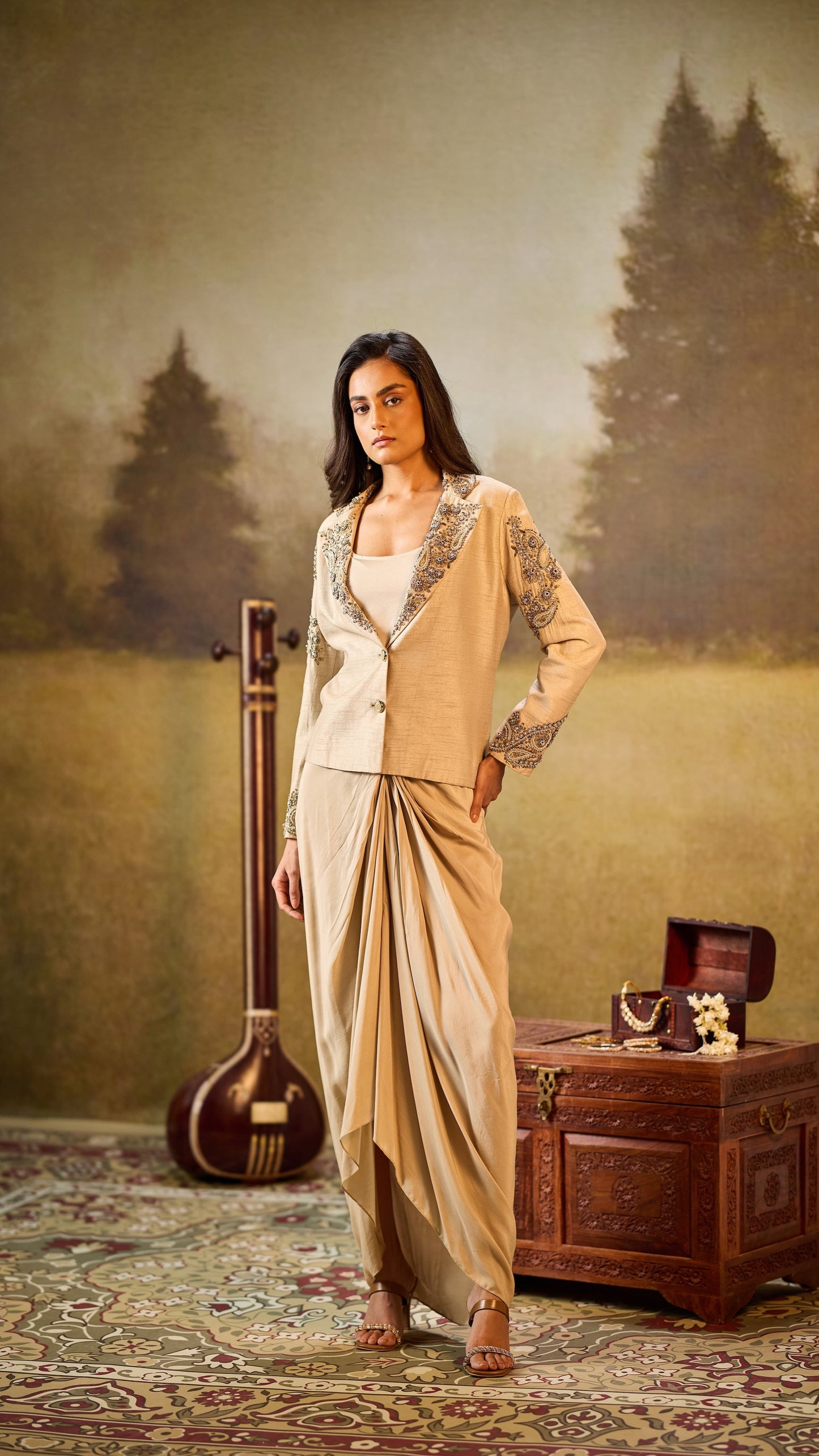 Woman in traditional outfit standing in a scenic outdoor setting with a wooden instrument and chest.