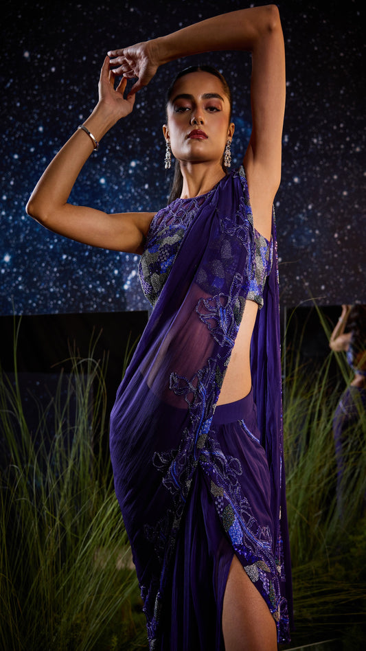 Woman in a purple saree against a starry night sky